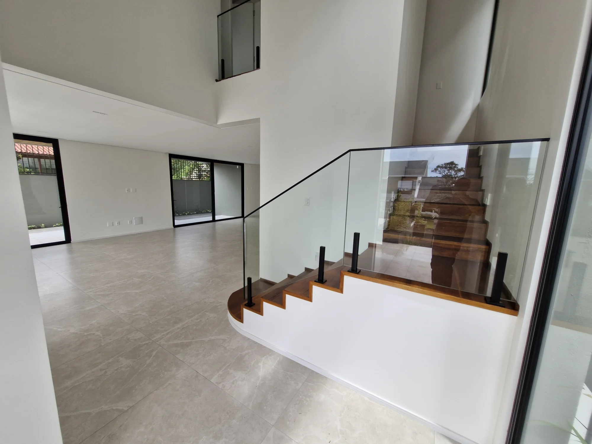 Interior amplo de residência de alto padrão com pé-direito duplo e muita luz natural